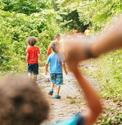 Kinder, die in einer Reihe spazieren gehen im Wald